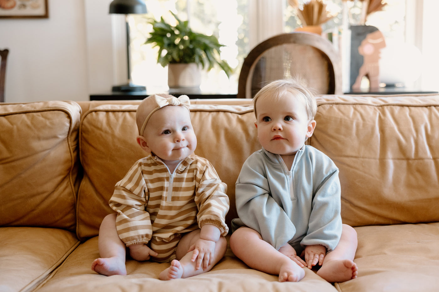 two babies sitting on a couch