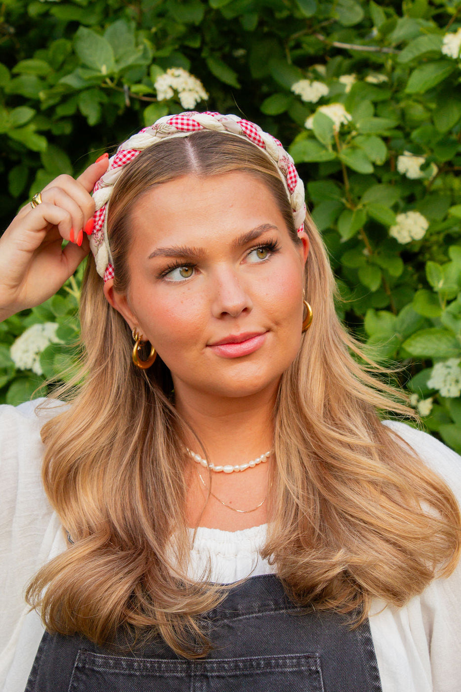 a woman with blonde hair wearing a headband and earrings