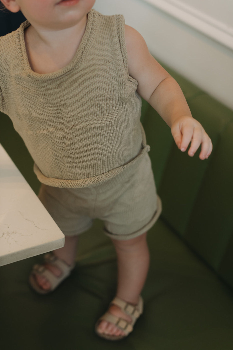 a baby standing near a table