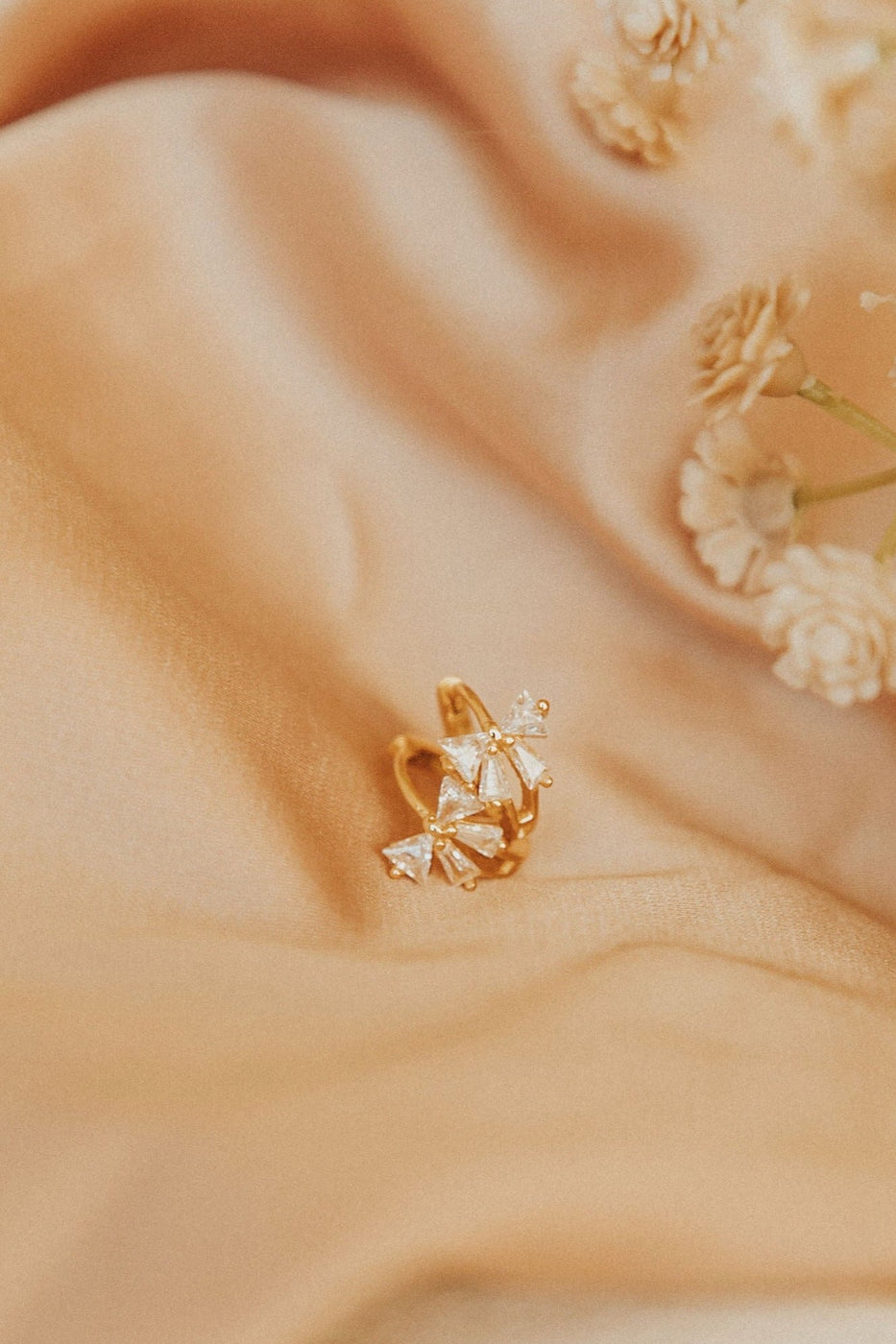 a gold ring with diamonds on a pink fabric