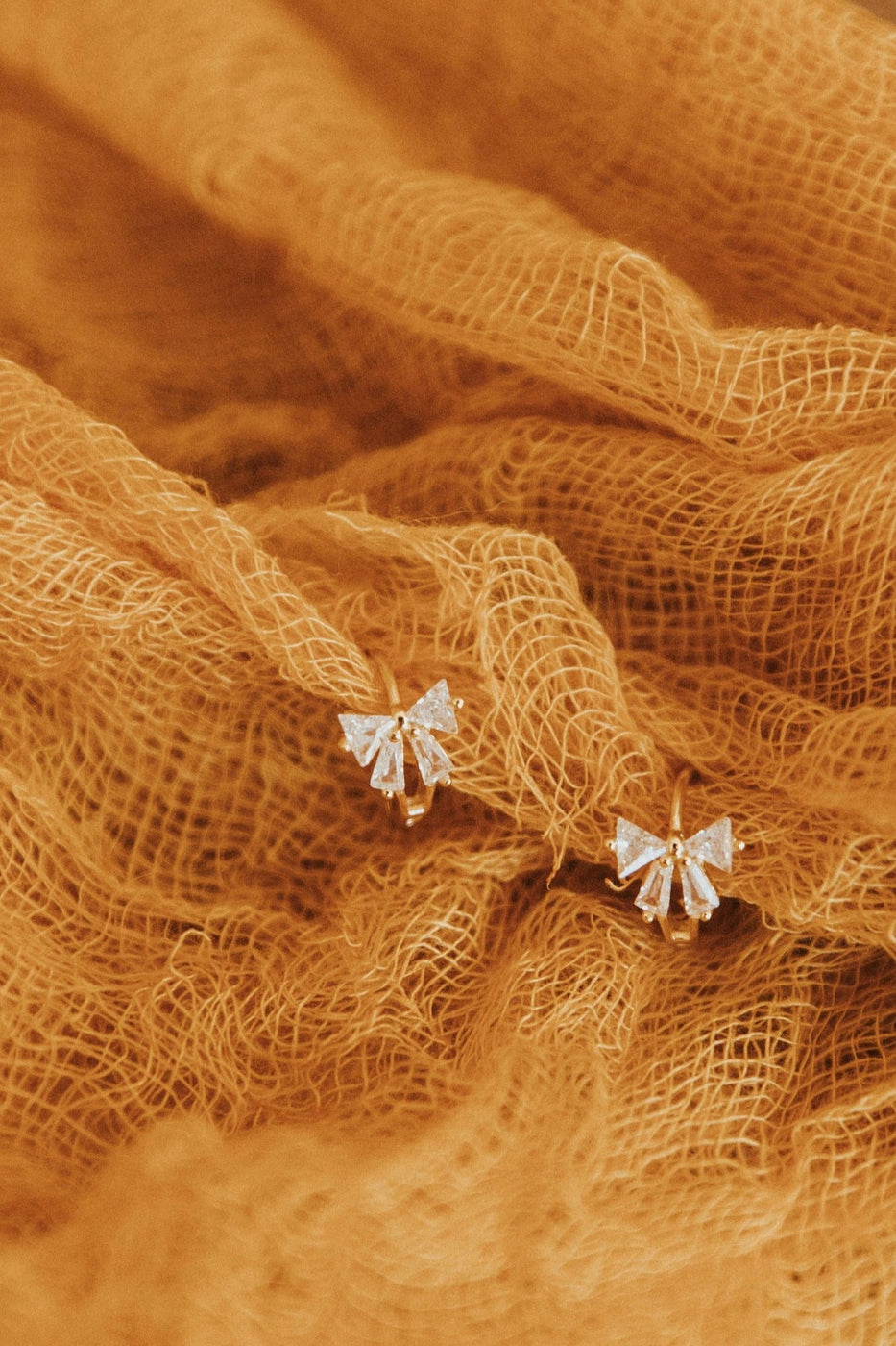 a pair of earrings on a cloth