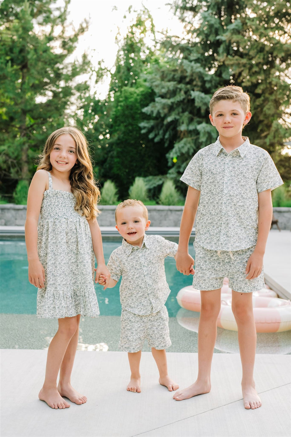 a group of children standing by a pool