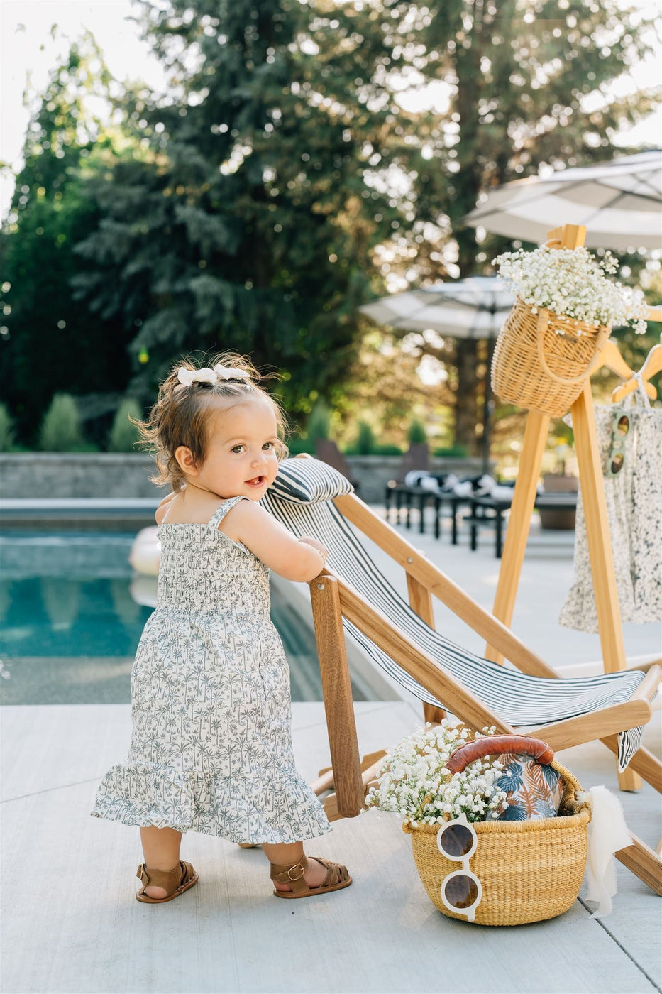 a little girl standing next to a chair