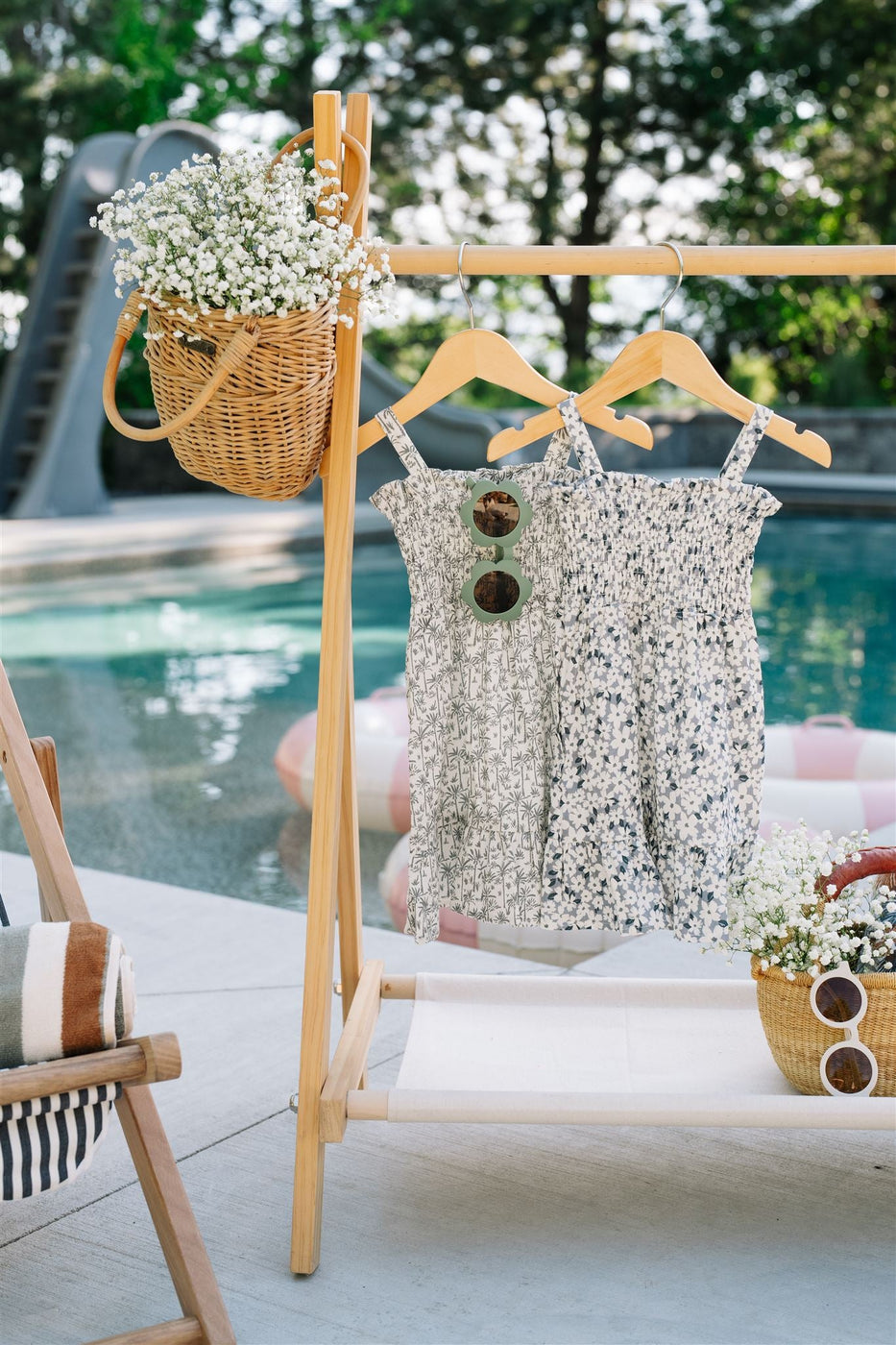 a dress and a basket of flowers on swingers by a pool