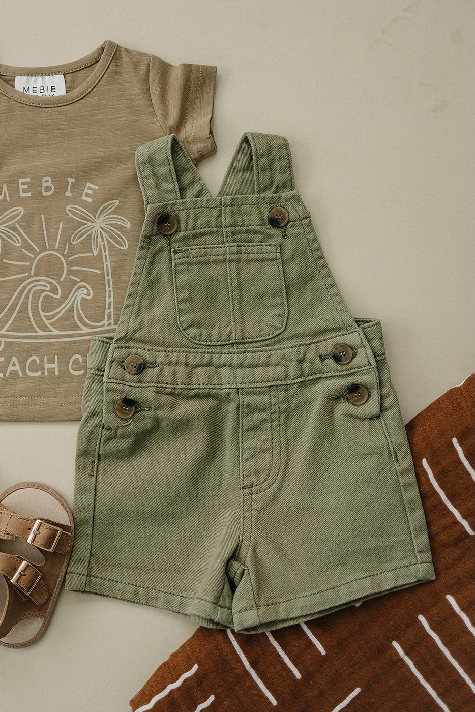 a green overalls and sandals