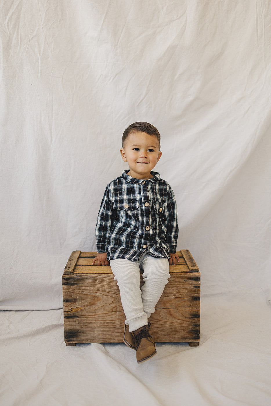 a boy sitting on a wooden box