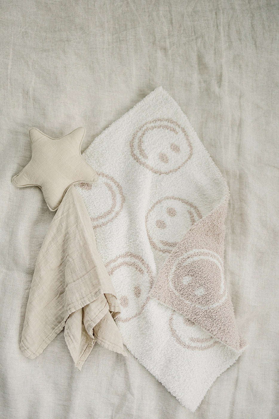 a white towel with a star and a pink towel on a white surface