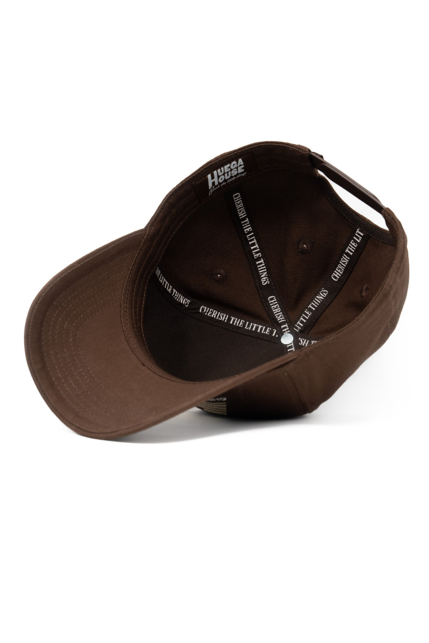 a brown baseball cap with white text on it