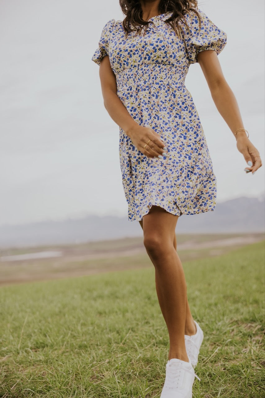 a woman in a dress walking in a field