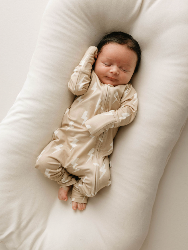 a baby sleeping in a white pillow