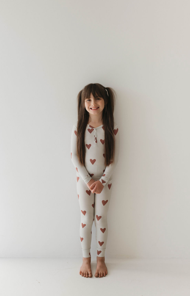 a girl in a white pajamas with red hearts