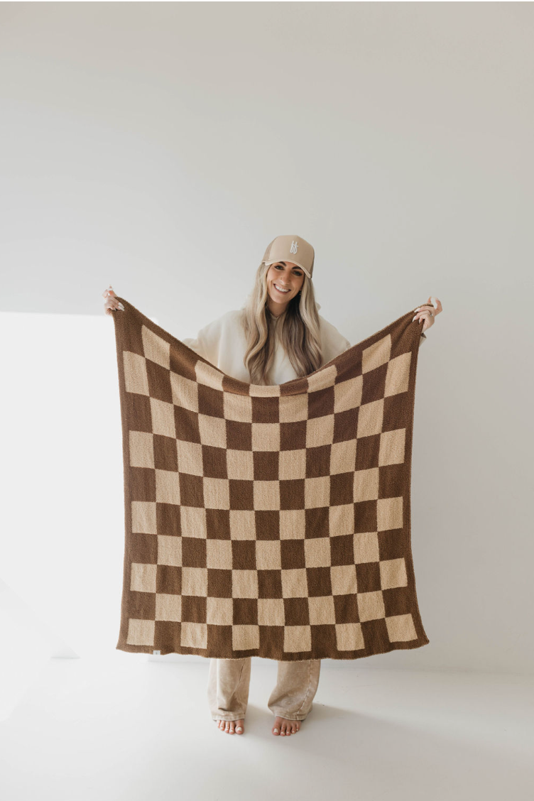a woman holding a checkered blanket