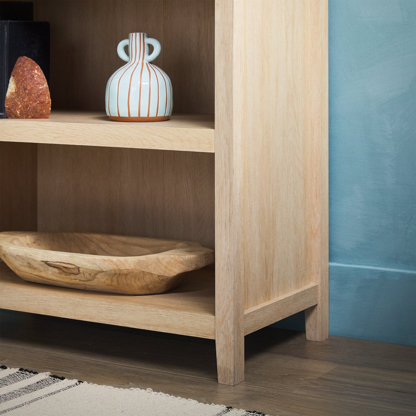 a wooden shelf with a vase and a bowl on it