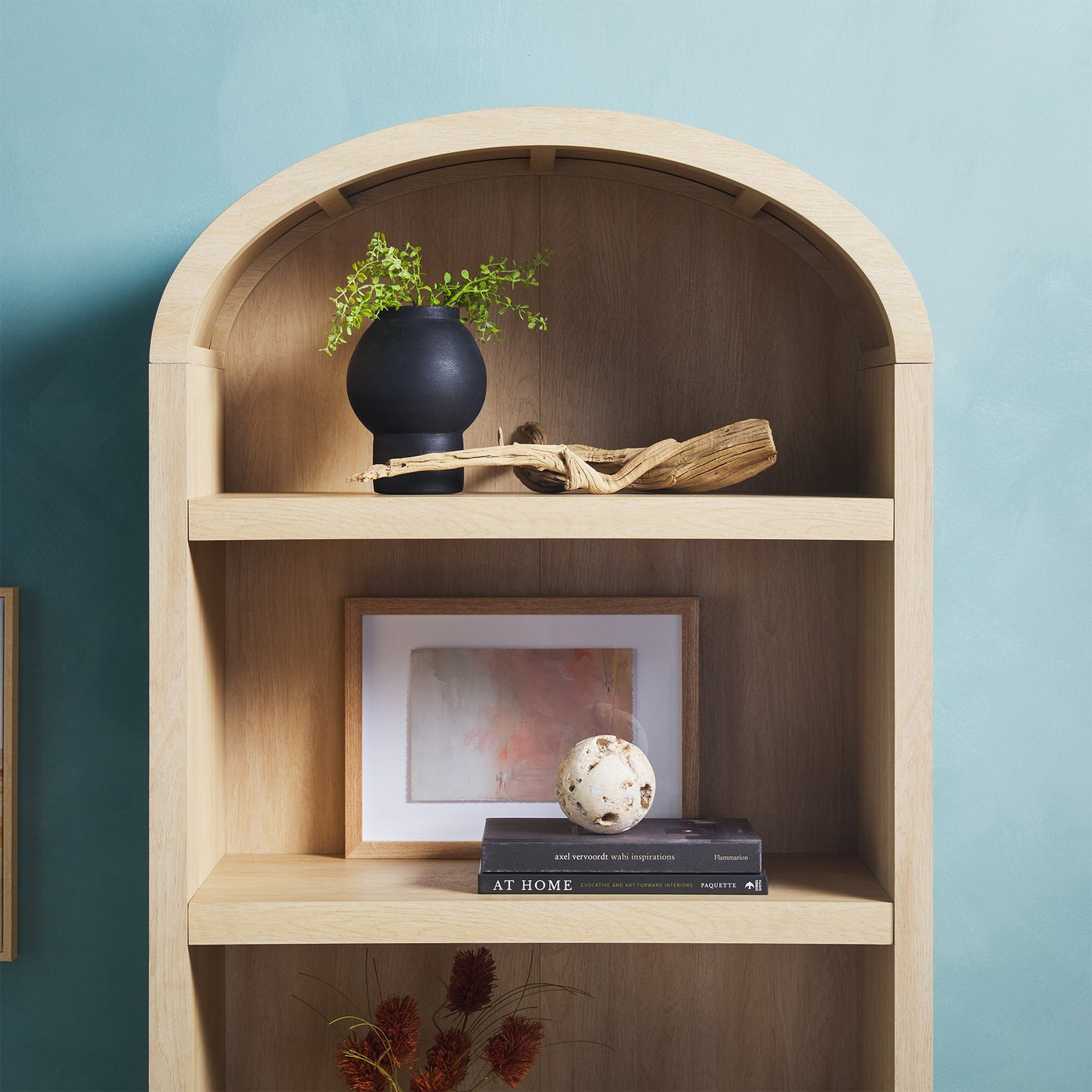 a shelf with a plant and a picture on it