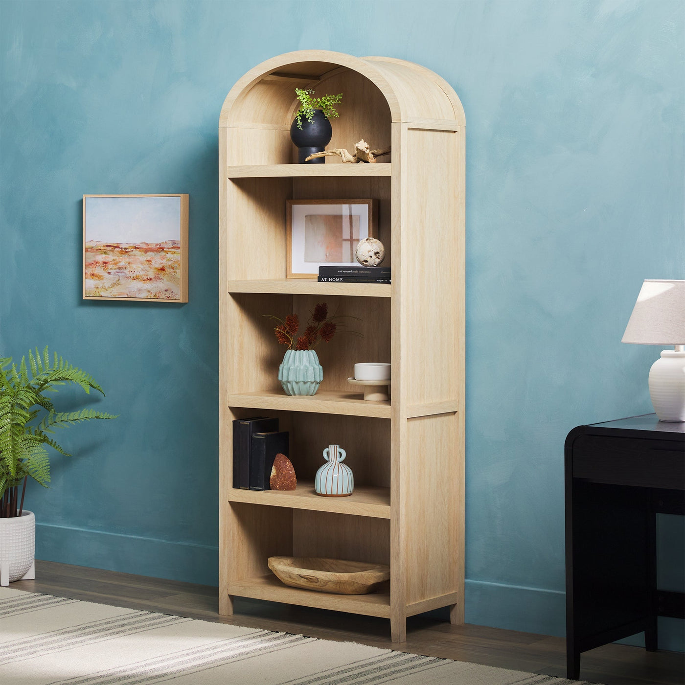 a bookcase with plants and a lamp