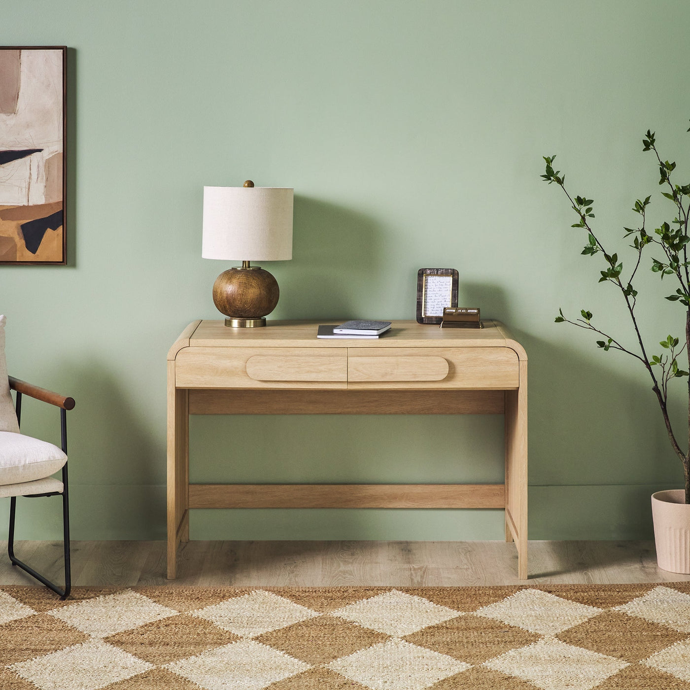 a desk with a lamp and a plant in a room