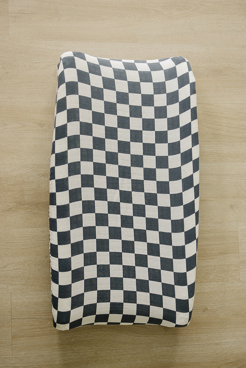 a black and white checkered blanket on a wood floor