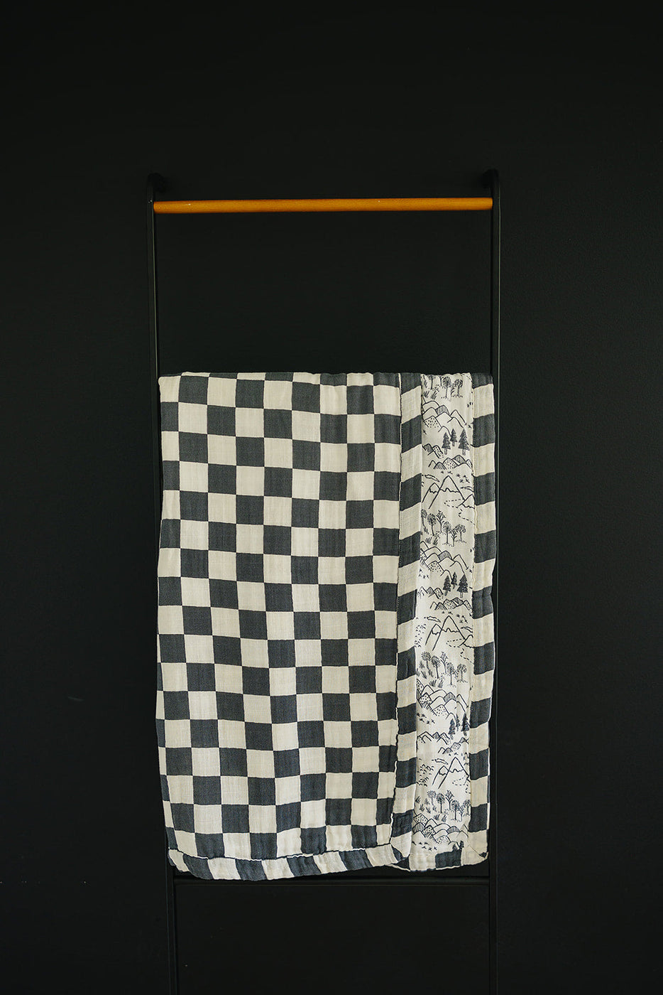 a black and white checkered towel on a black wall