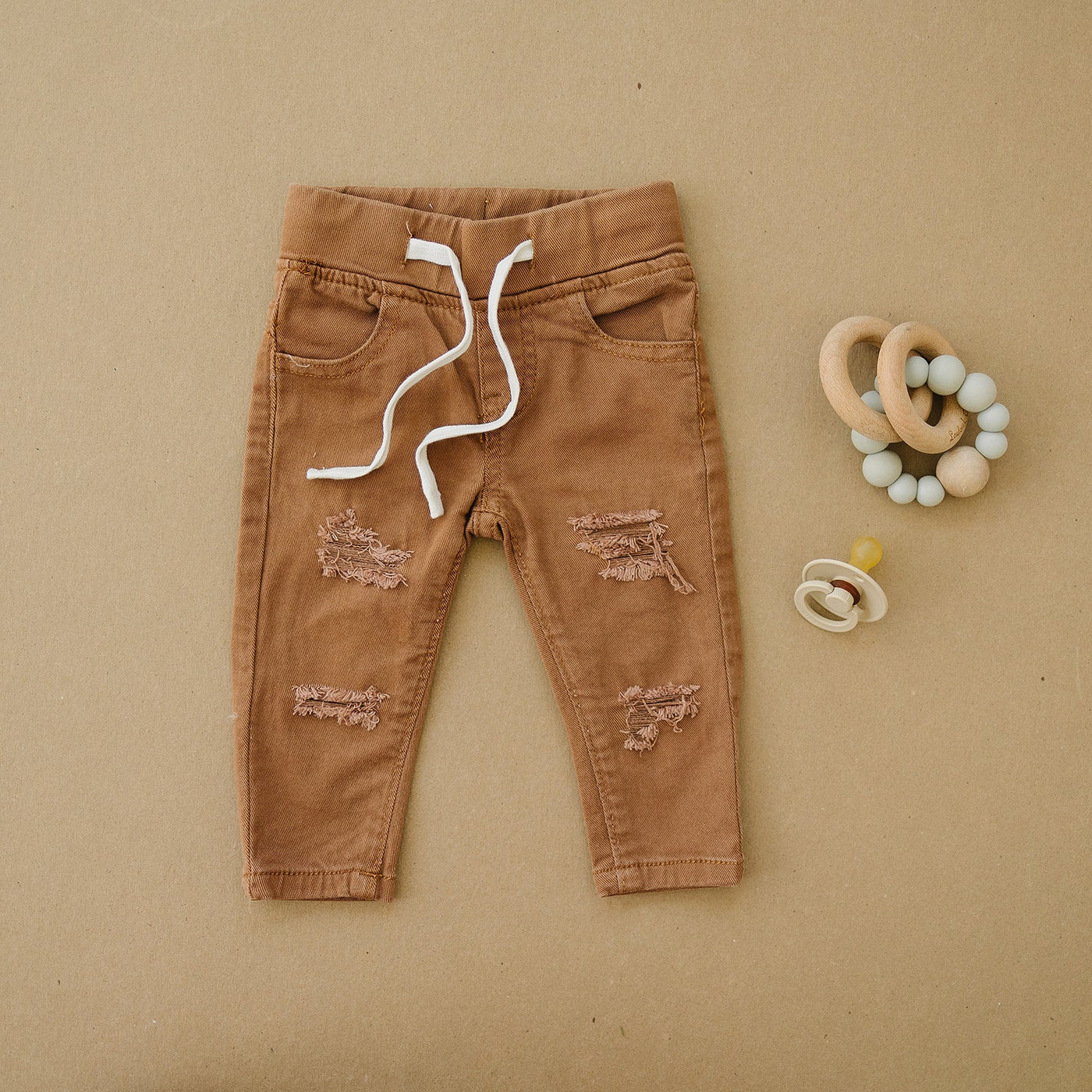 a pair of brown pants with white laces and a pacifier