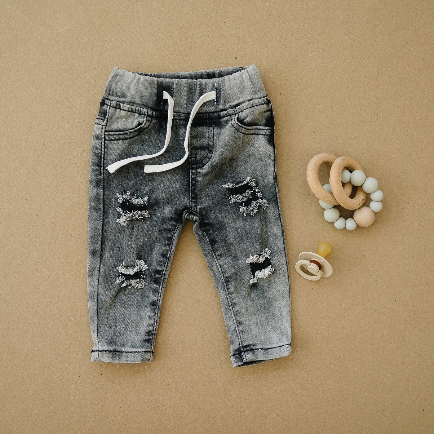 a pair of jeans with holes and a pacifier