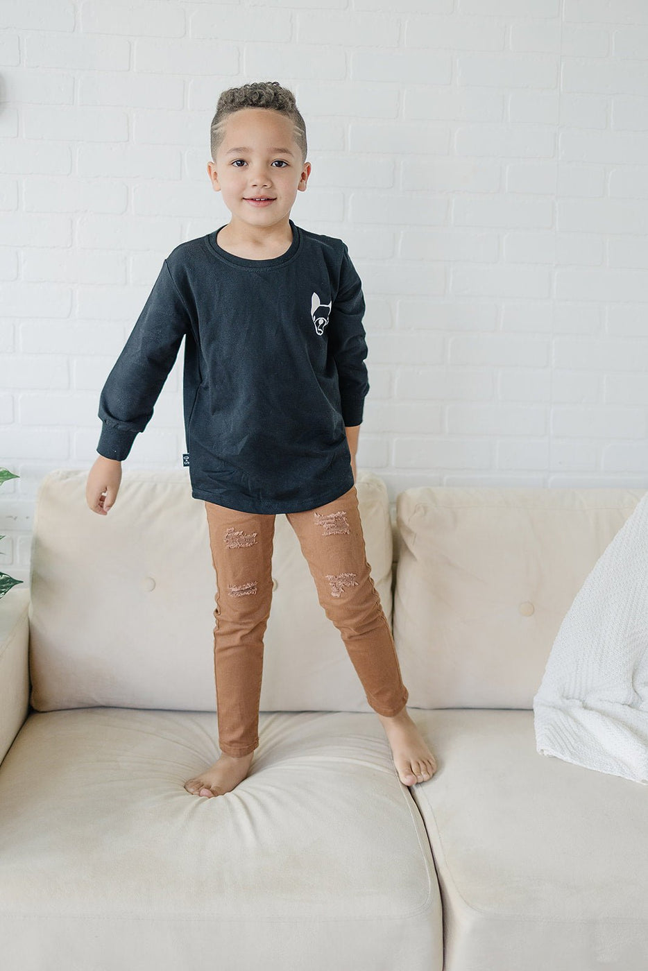 a boy standing on a couch