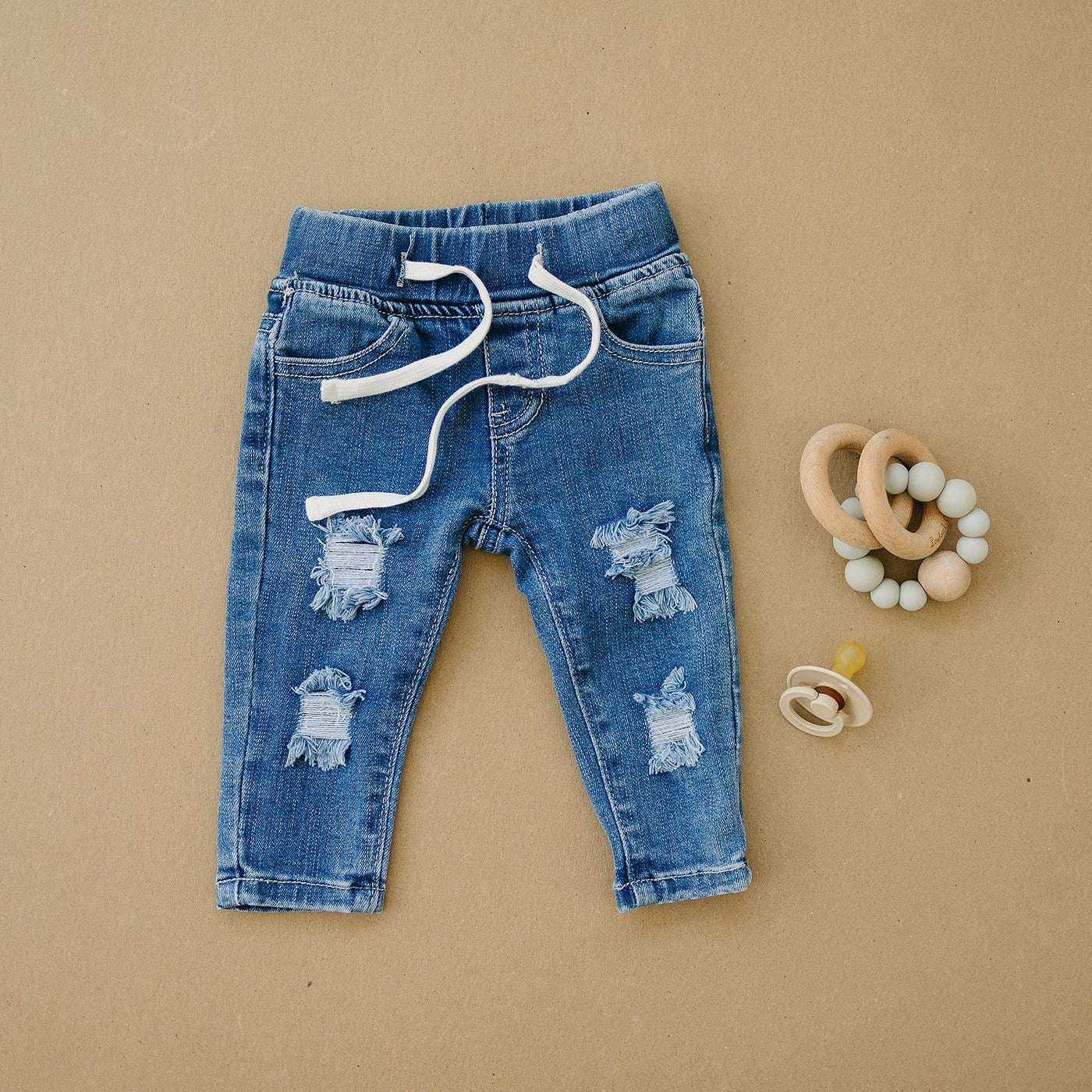 a pair of jeans with holes and a pacifier