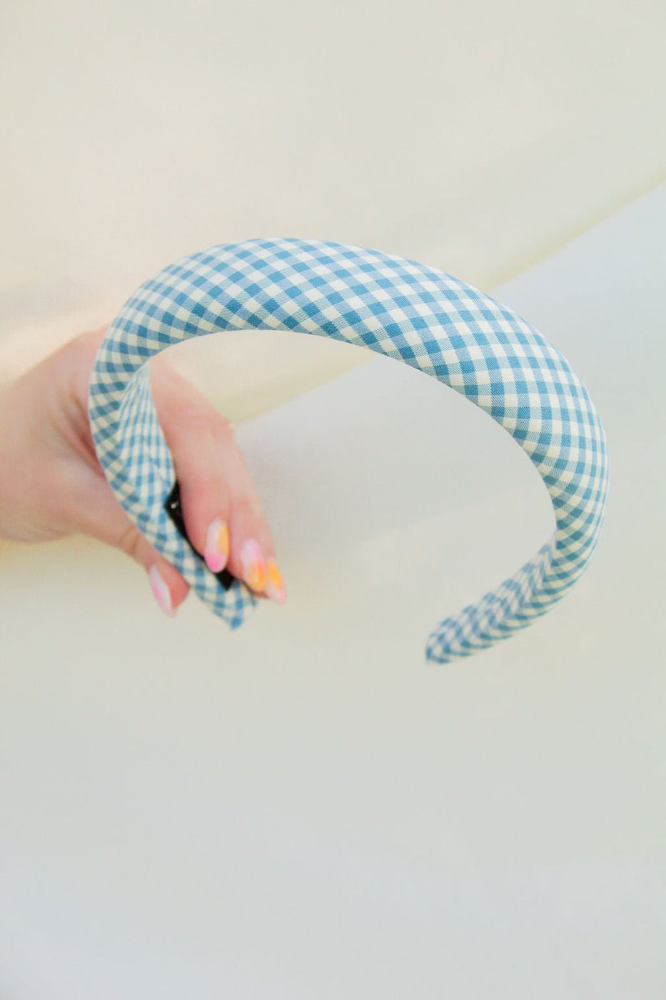 a hand holding a blue and white headband