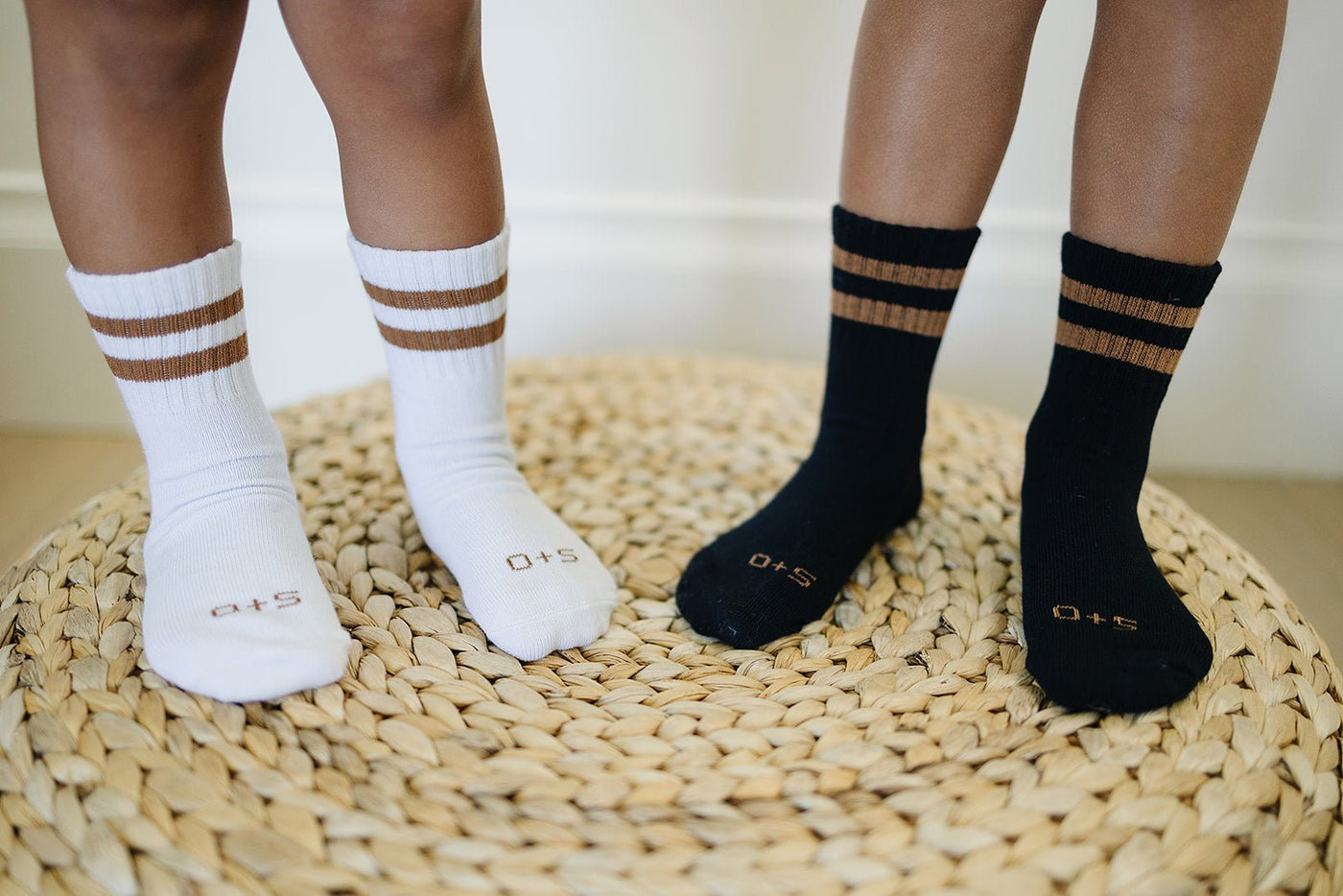 a pair of feet with socks on a woven mat