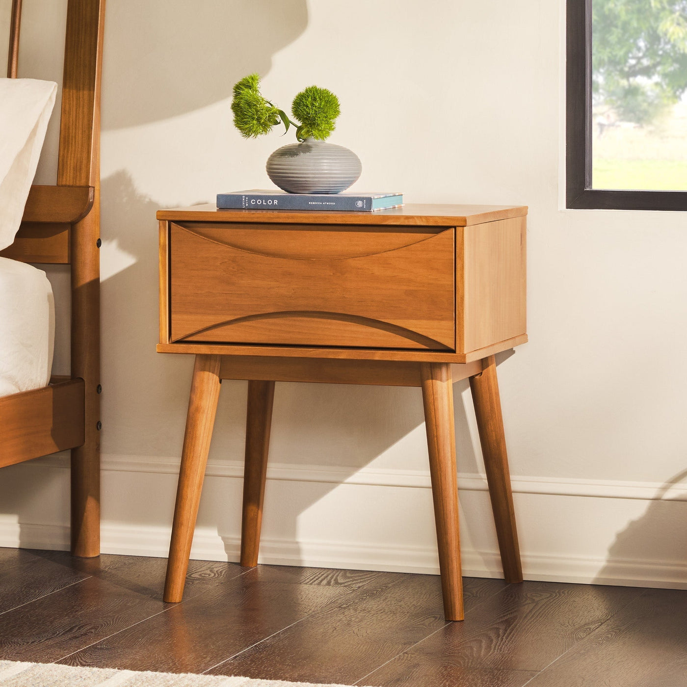 a wood nightstand with a plant on top