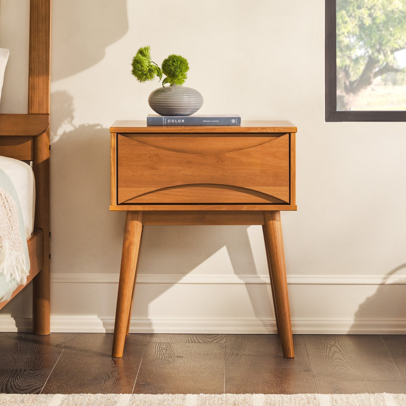 a wood nightstand with a plant on top