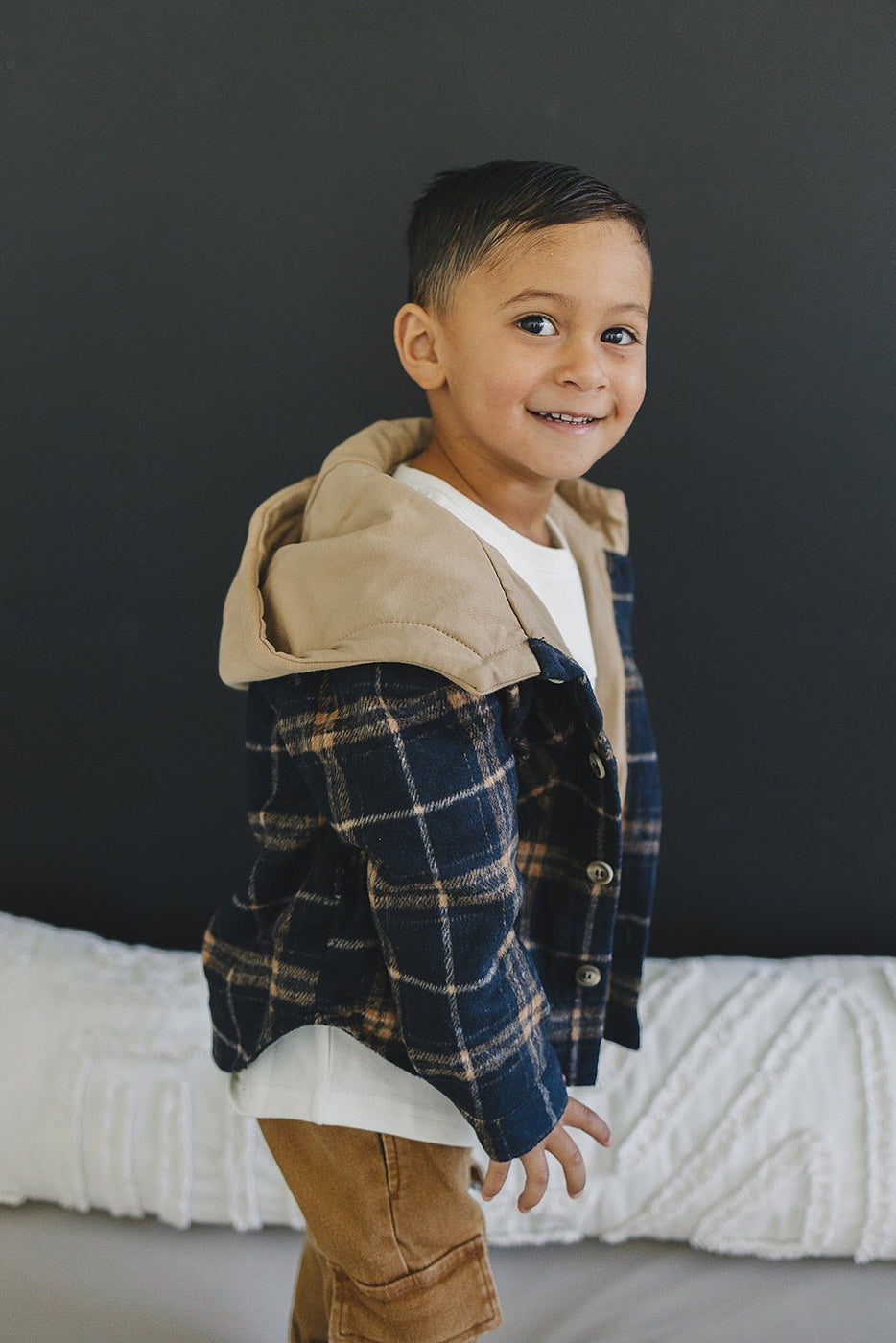 a boy standing on a bed