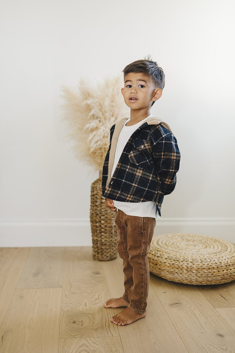 a boy standing in front of a wicker basket