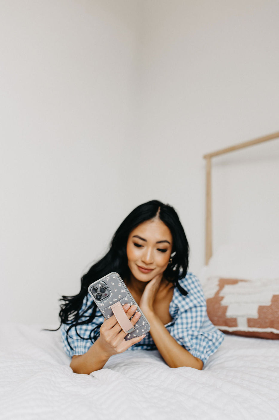 a woman lying on a bed holding a phone