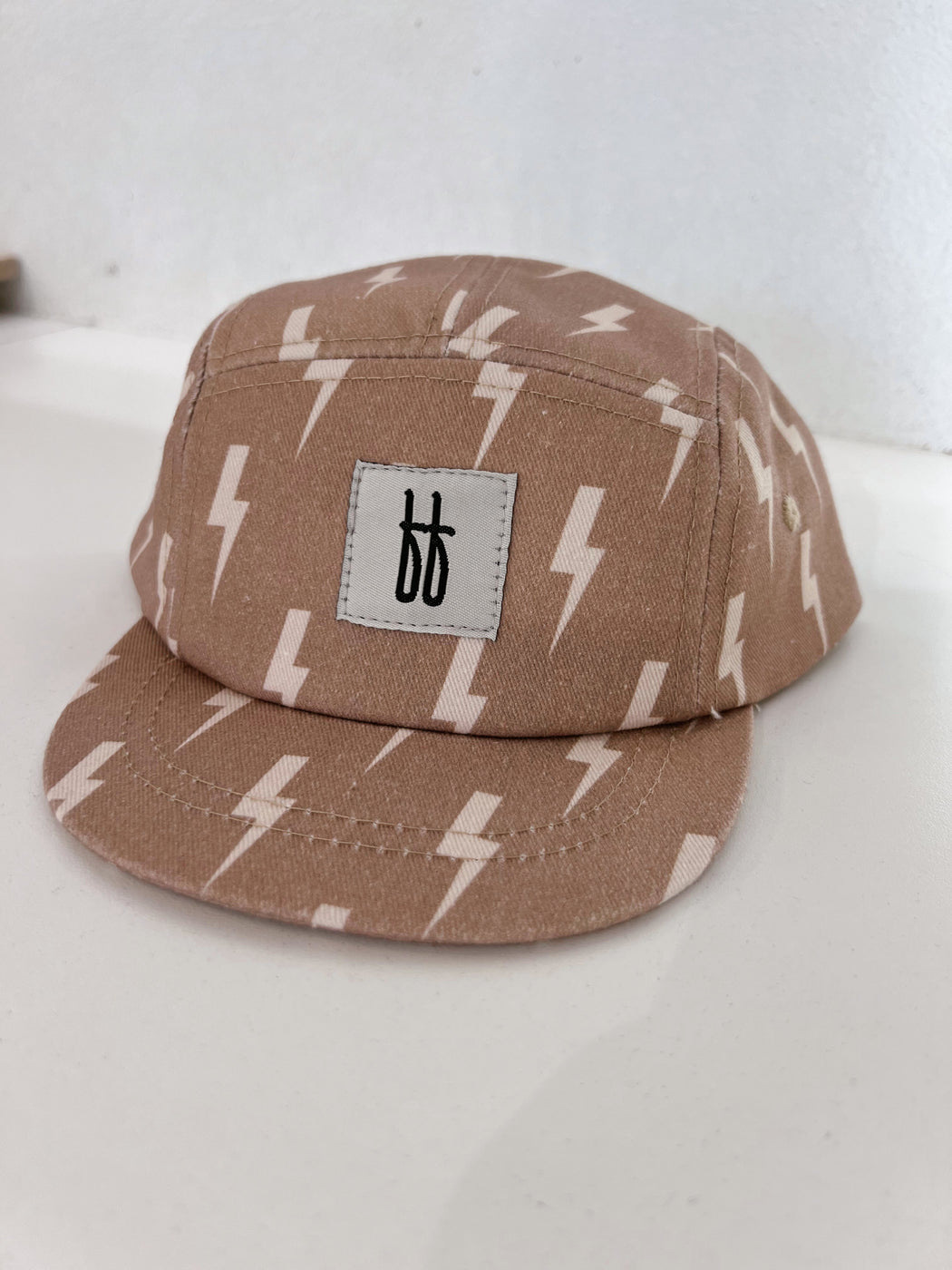 a brown baseball cap with white lightning bolts on it