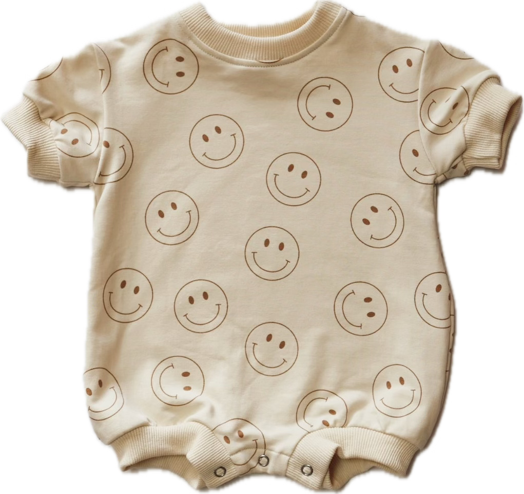 a white baby bodysuit with smiley faces on it