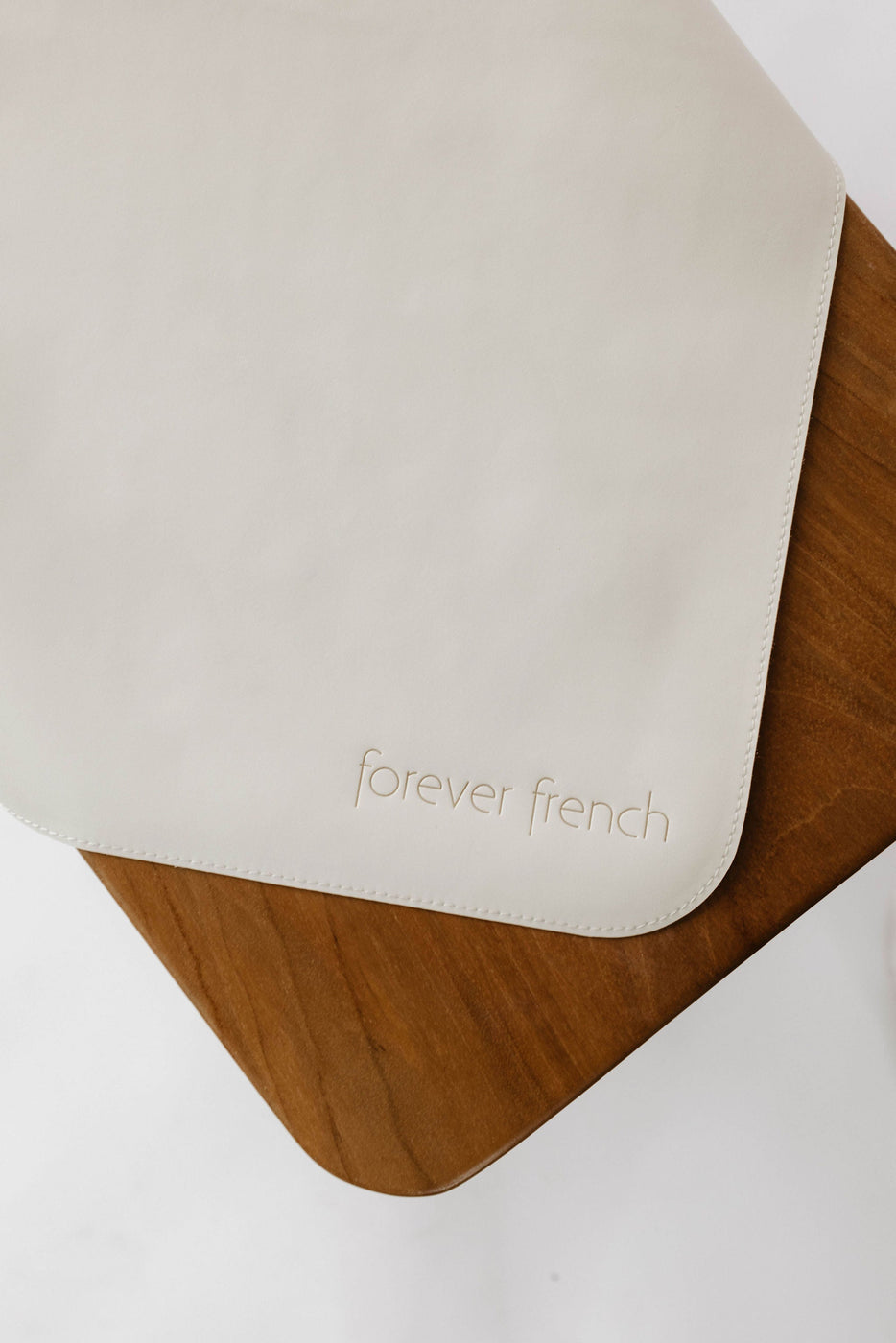 a white place mat on a wood surface