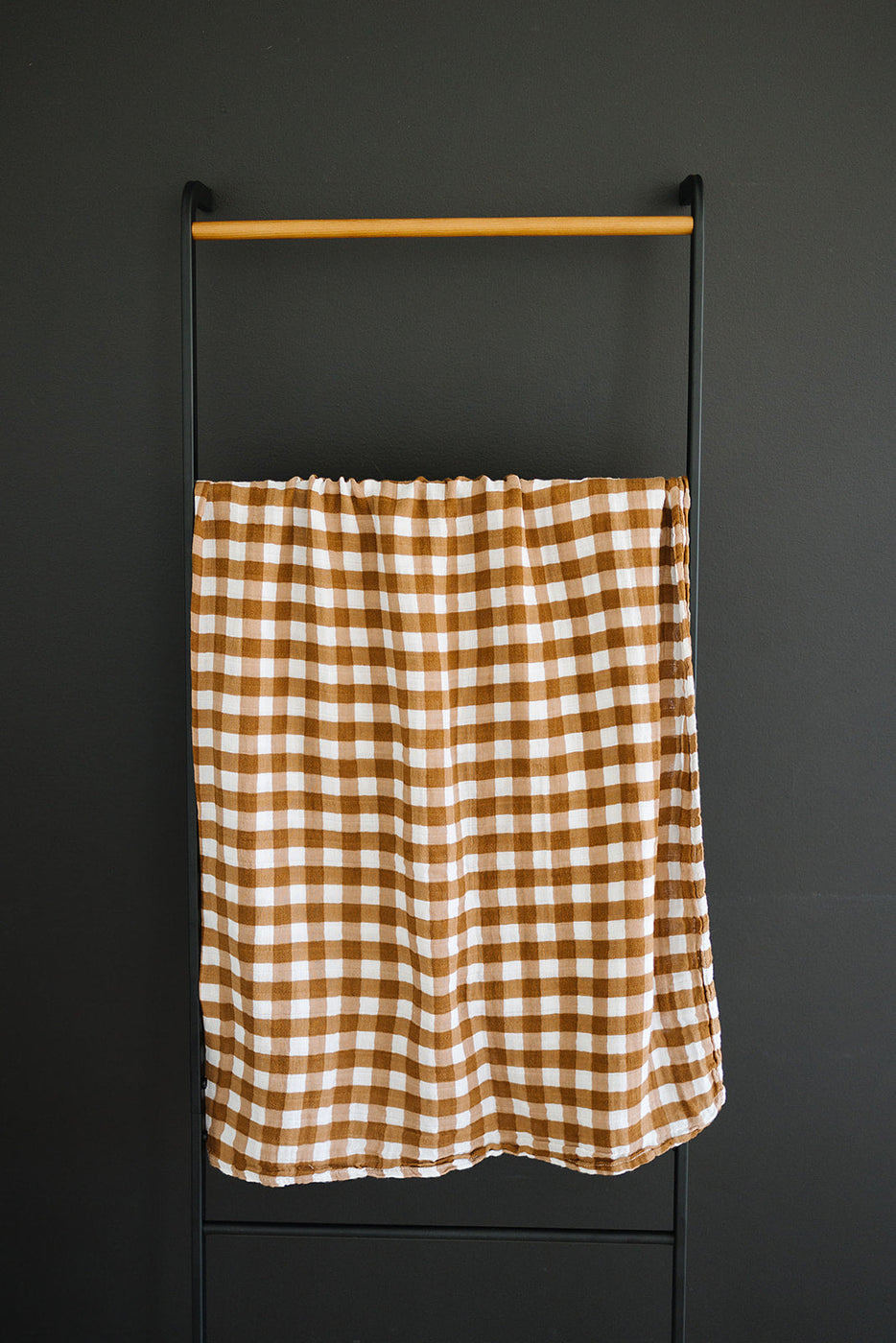a brown and white checkered towel on a metal rod