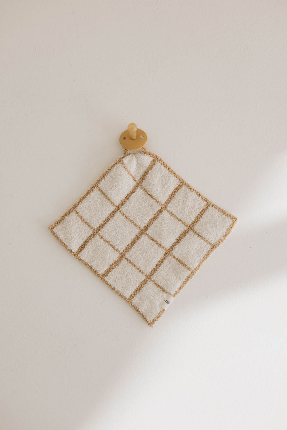 a white and tan towel on a hook