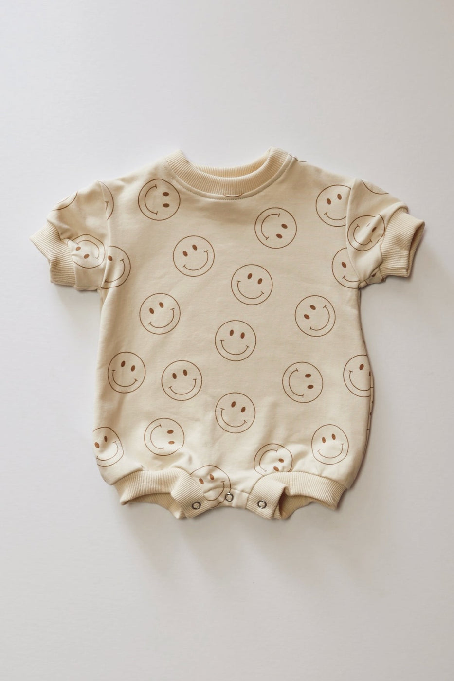 a baby clothes with smiley faces on it