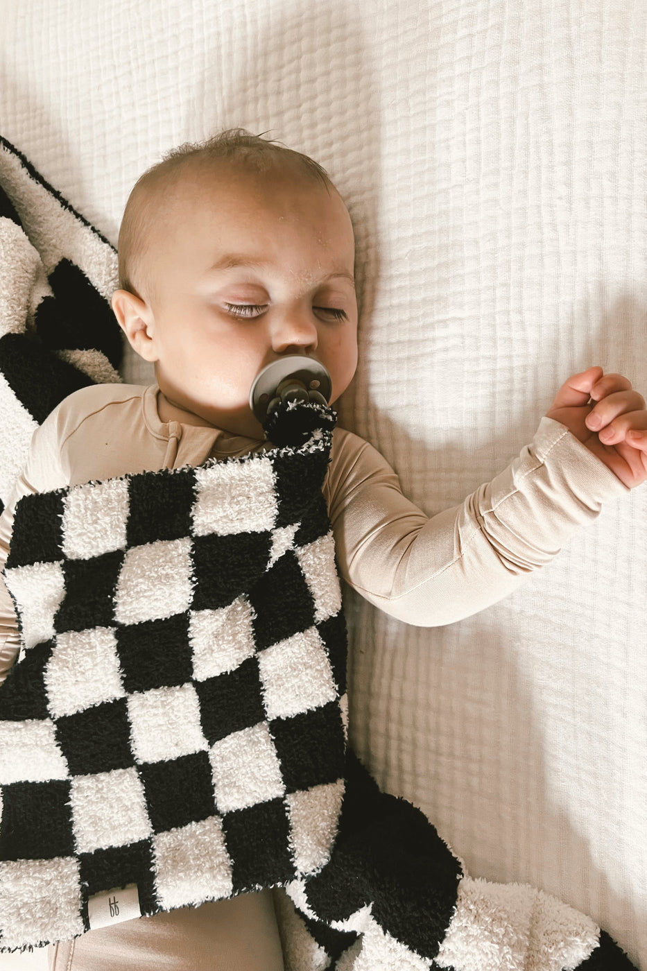 a baby sleeping with a pacifier in its mouth