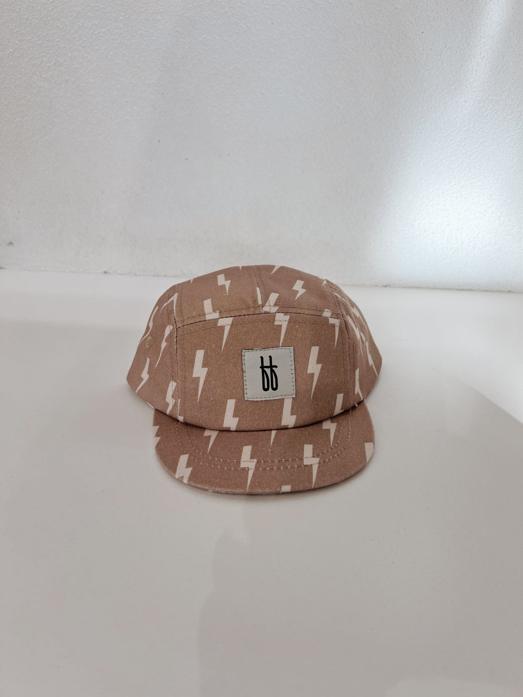 a brown baseball cap with lightning bolt design