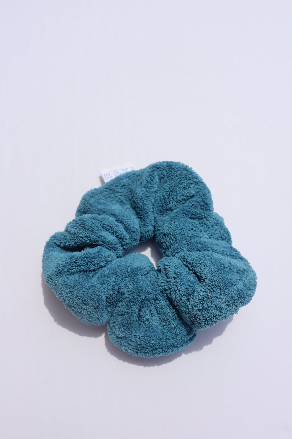 a blue hair scrunchie on a white surface