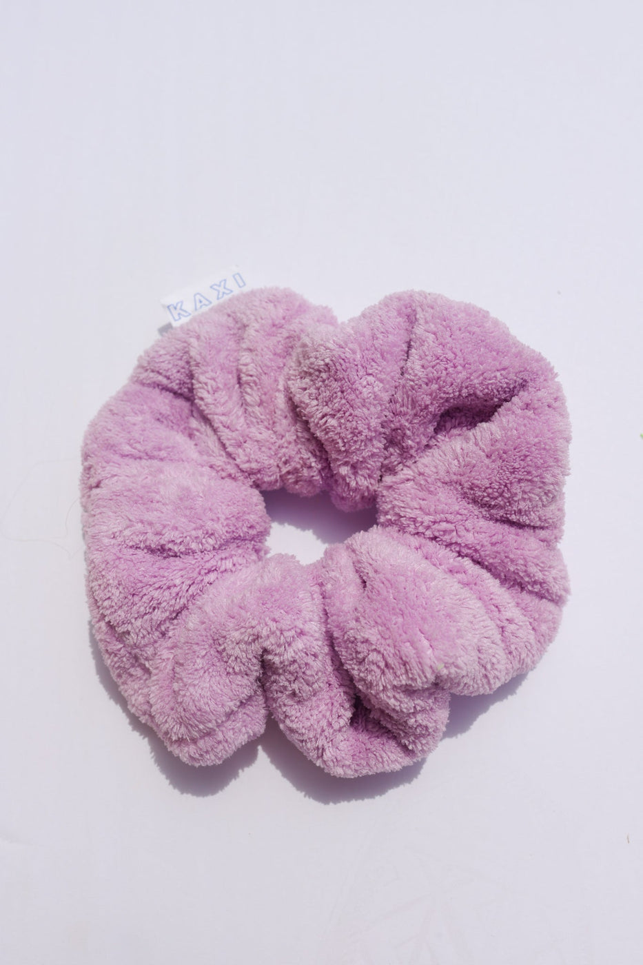 a purple hair scrunchie on a white surface
