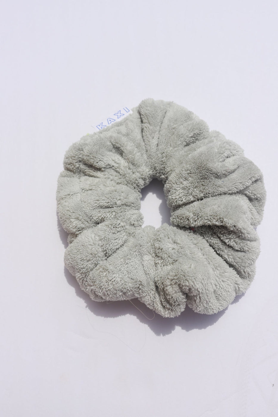 a gray hair scrunchie on a white surface