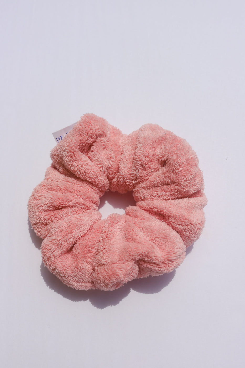 a pink hair scrunchie on a white surface