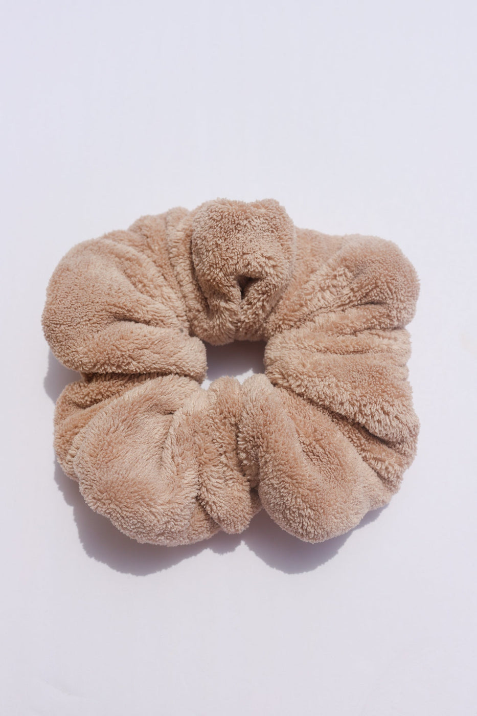 a brown hair scrunchie on a white surface
