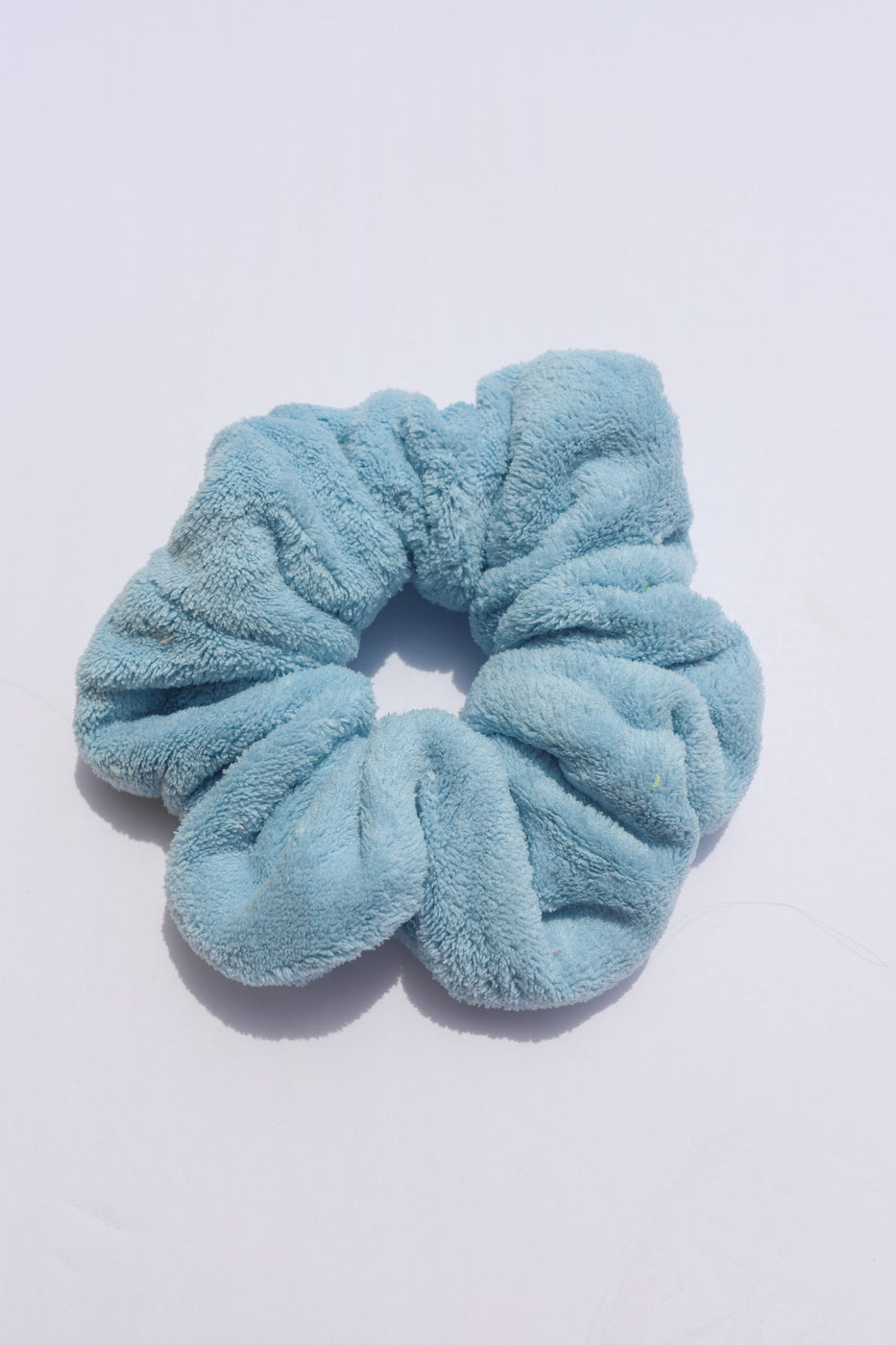 a blue hair scrunchie on a white surface