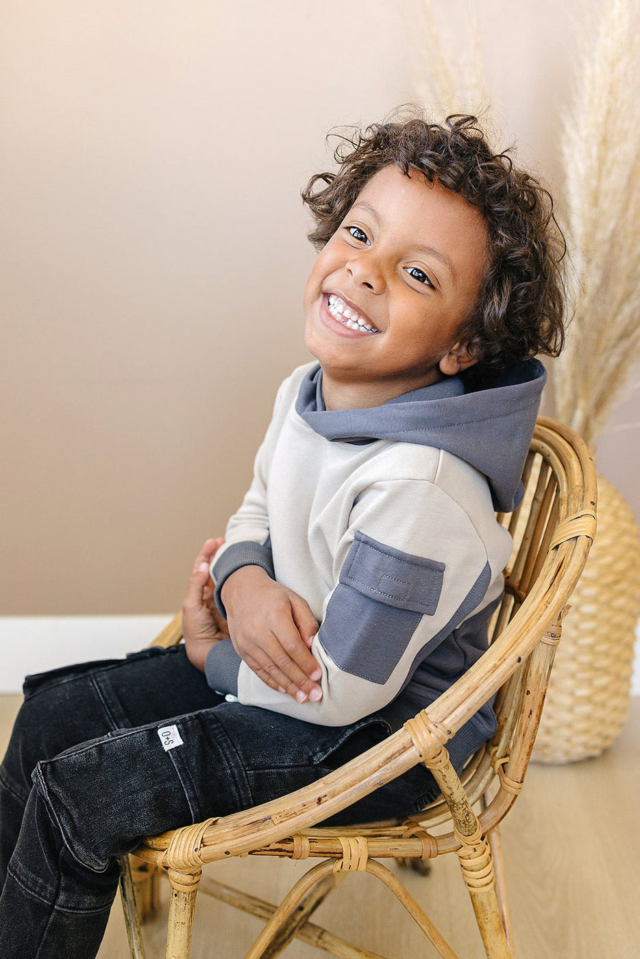 a boy sitting in a chair smiling