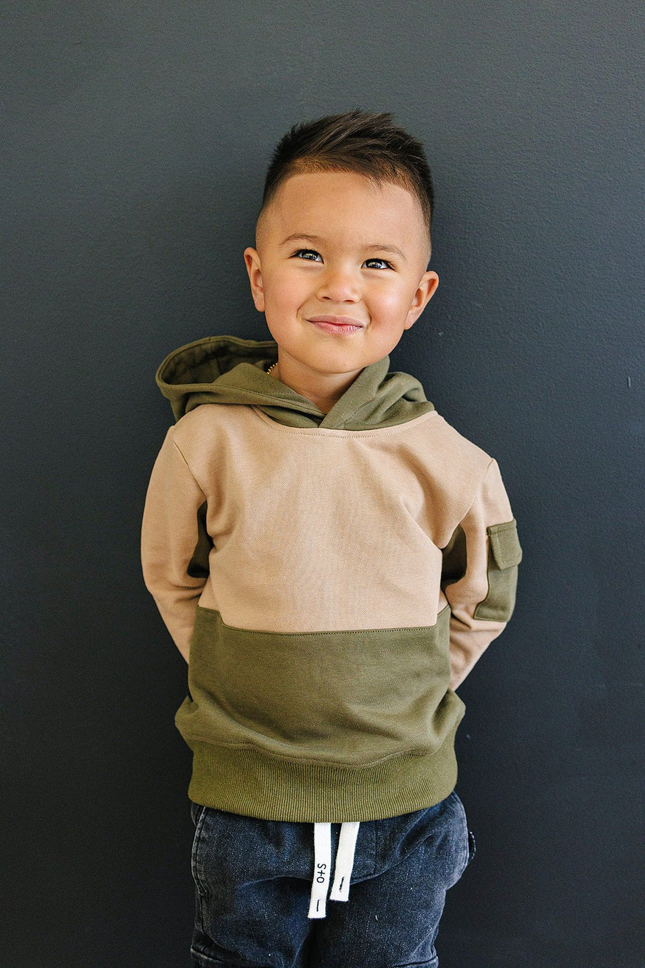 a boy standing in front of a wall