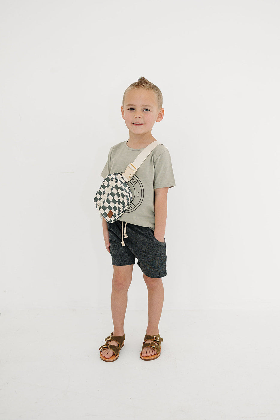 a boy standing with a bag